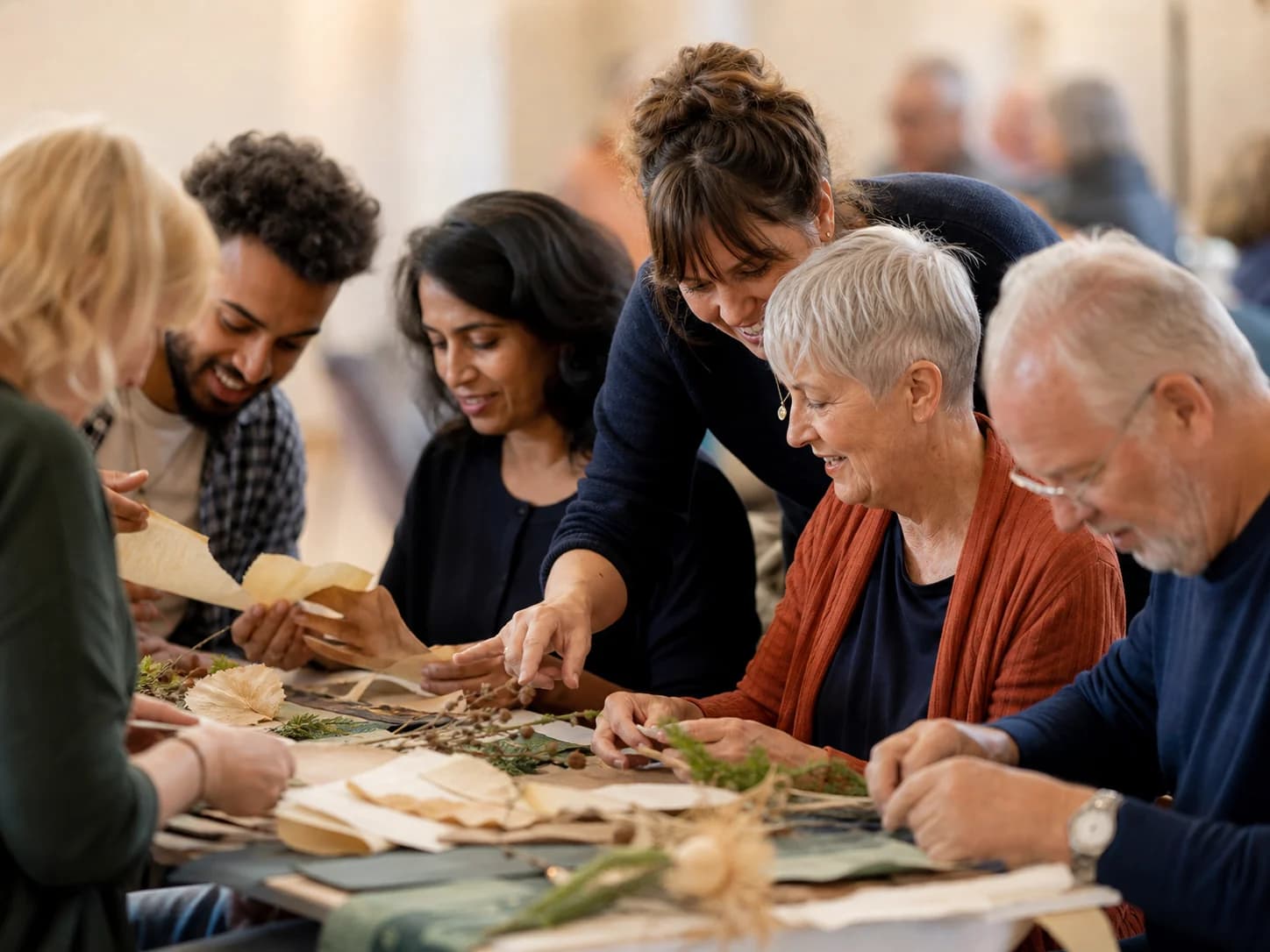 A mixed-age group creating together around a workshop table